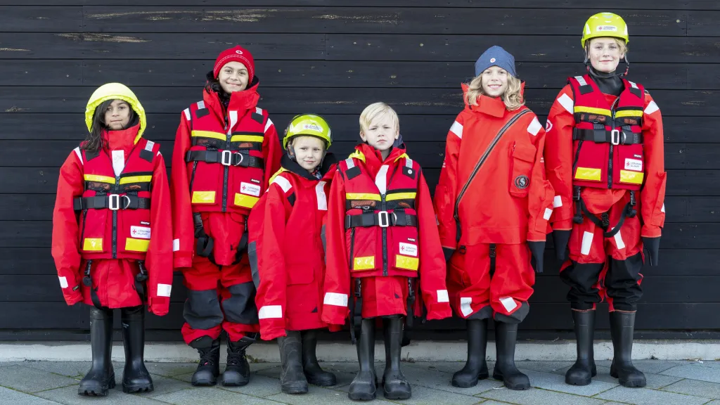 Sex barn står uppradade med för stora sjöräddningskläder på sig. 