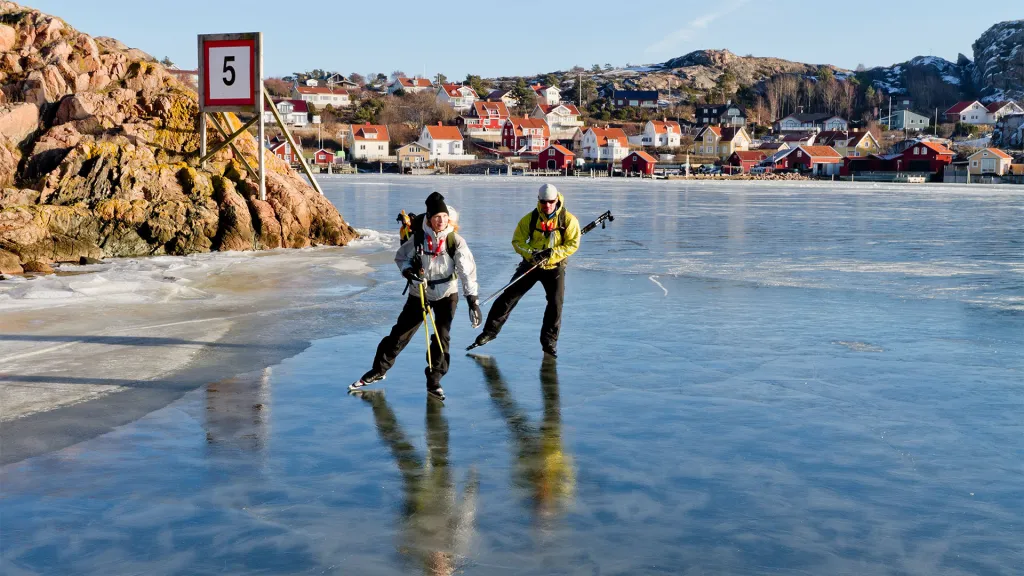 Två personer som åker skridskor på isen