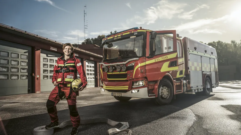 Åsa står framför en brandbil.