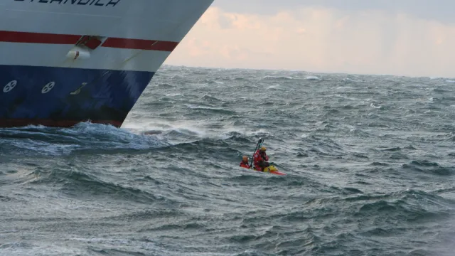 Rescuerunner åker framför ett större fartyg