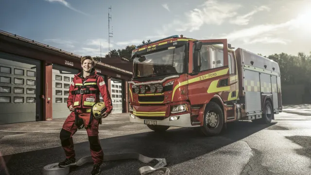 Åsa står framför en brandbil.